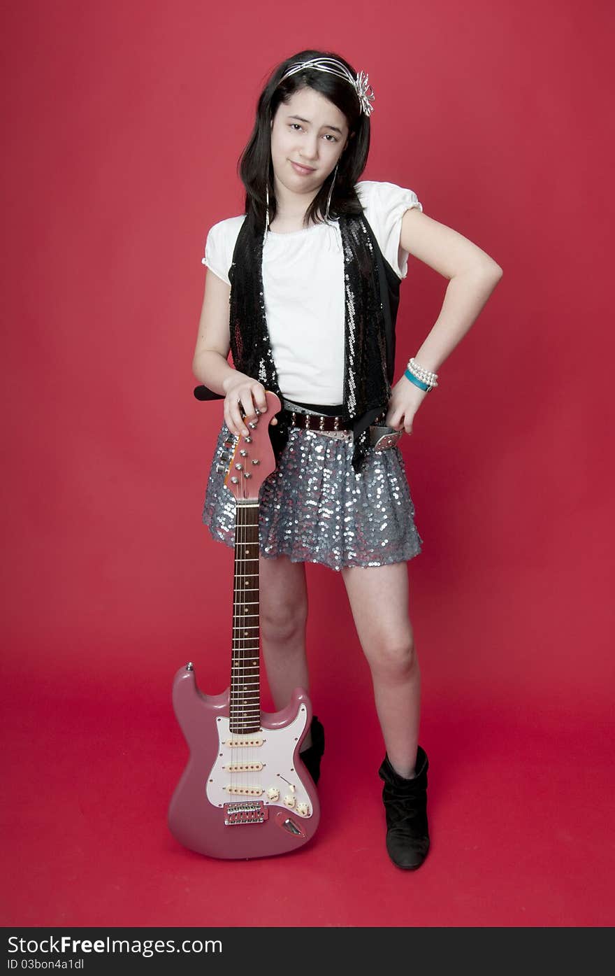 Preteen girl with attitude problem holding pink guitar. Preteen girl with attitude problem holding pink guitar