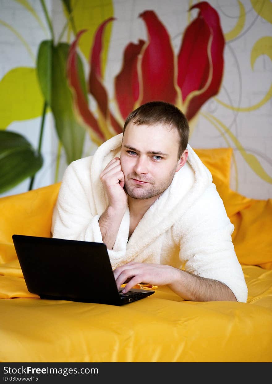 Handsome Man Lying In Bed With Laptop