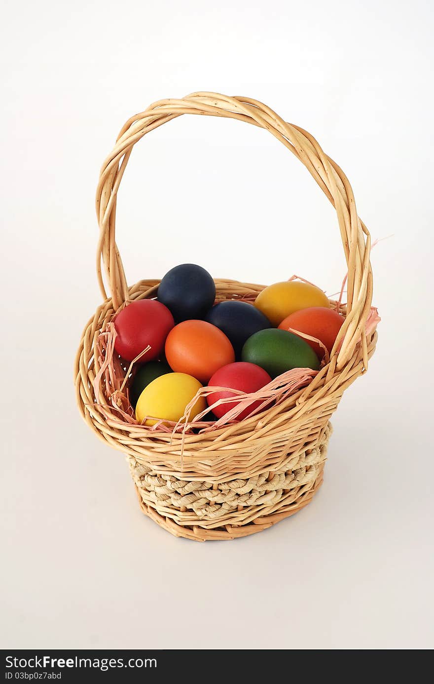 Painted Easter eggs in the Easter basket on the white background