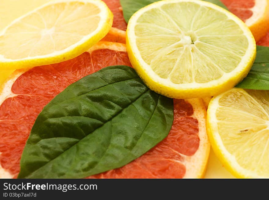 Fresh juicy grapefruits with green leafs close up