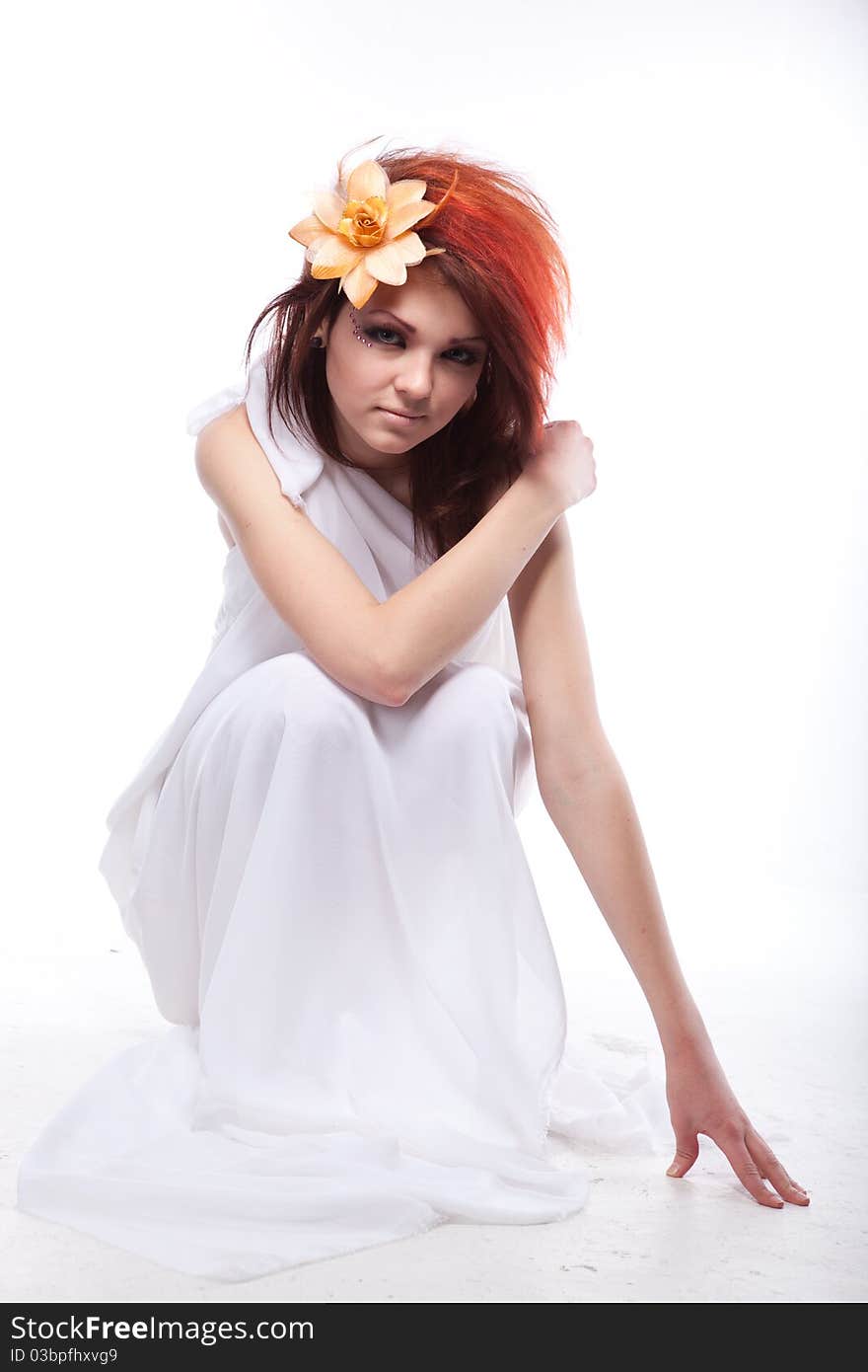 Portrait of beautiful woman with spring flower in hair on white