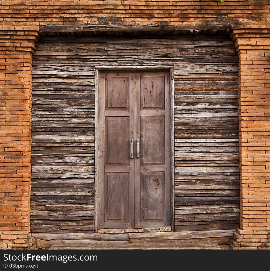 Old solid wood door and wall with bricks line. Old solid wood door and wall with bricks line.