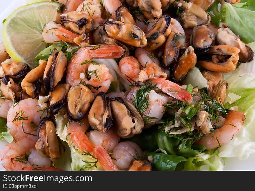 A photo of seafood: shrimps, mussels and lettuce