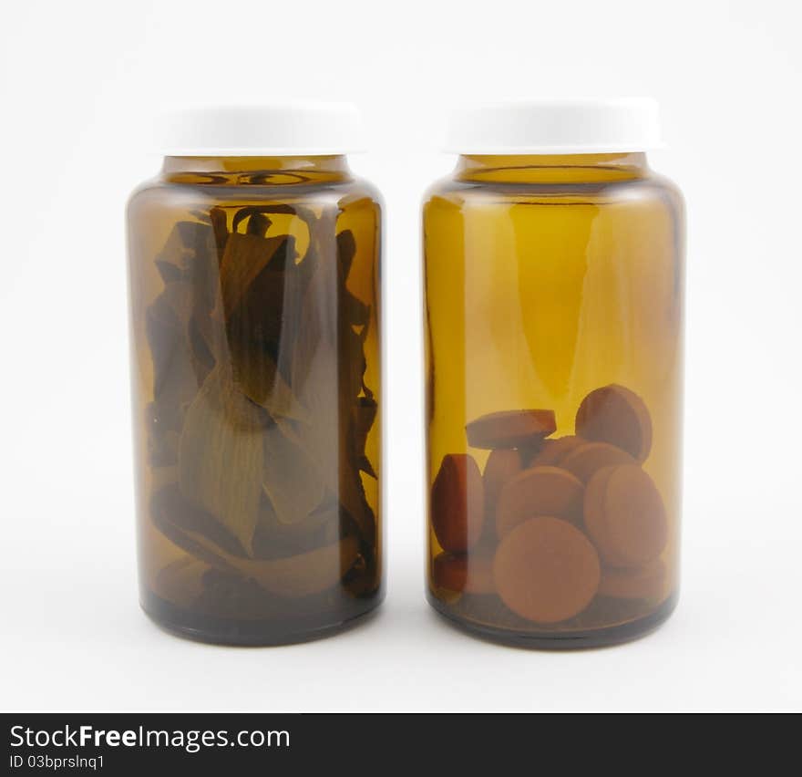 Two medical bottles: one with herbs and the other with pills. Two medical bottles: one with herbs and the other with pills