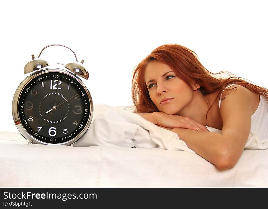 Young woman lying in bed with alarm clock. Young woman lying in bed with alarm clock