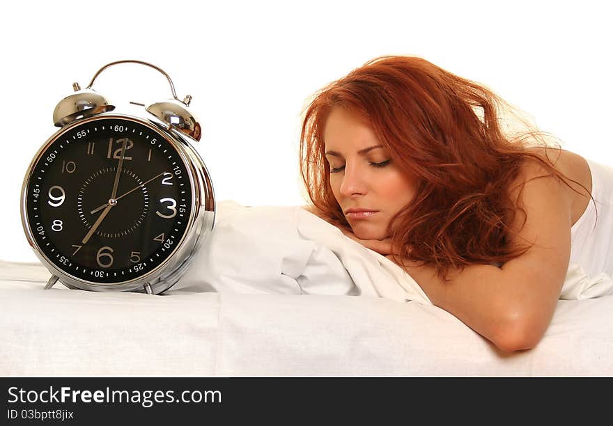 Young woman lying in bed with alarm clock. Young woman lying in bed with alarm clock