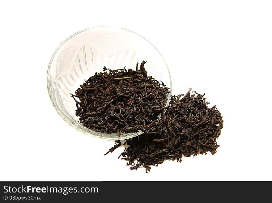 A glass cup of dried black tea on white background