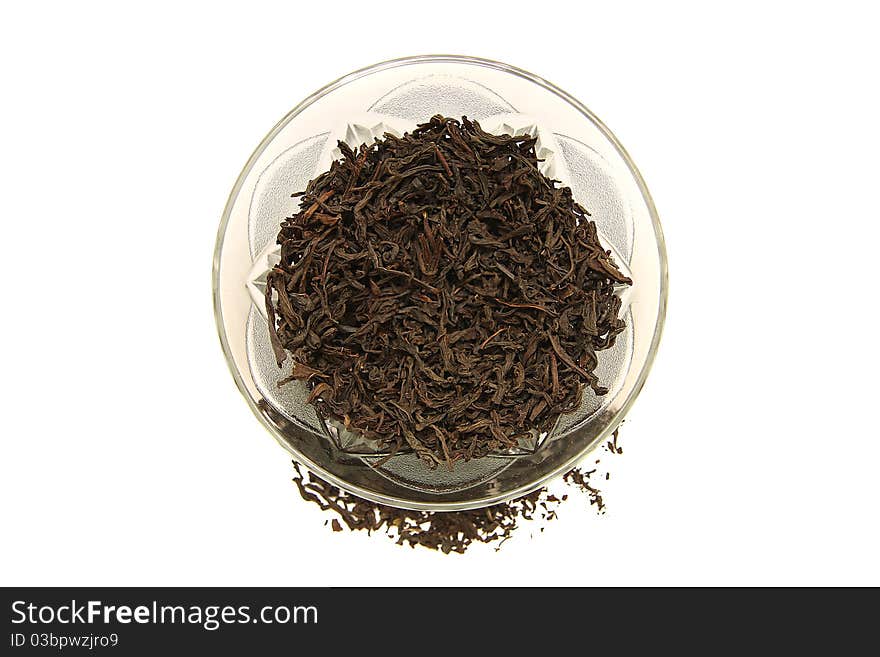 A glass cup of dried black tea on white background