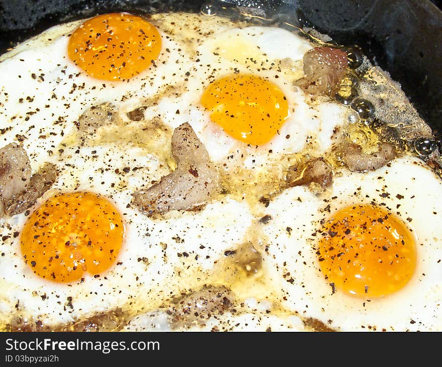 Scrambled eggs with bacon and spices in a pan