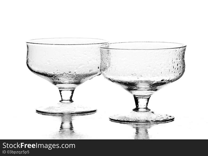 Two wine glasses with drops of water on it. White background. Studio shot. Two wine glasses with drops of water on it. White background. Studio shot.