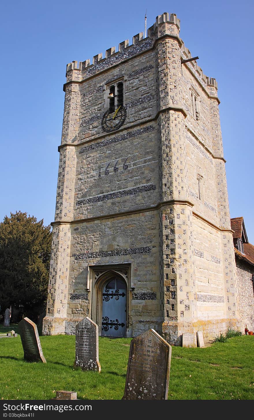 Medieval English Village Church and Tower with Clock viewed from the Graveyard. Medieval English Village Church and Tower with Clock viewed from the Graveyard