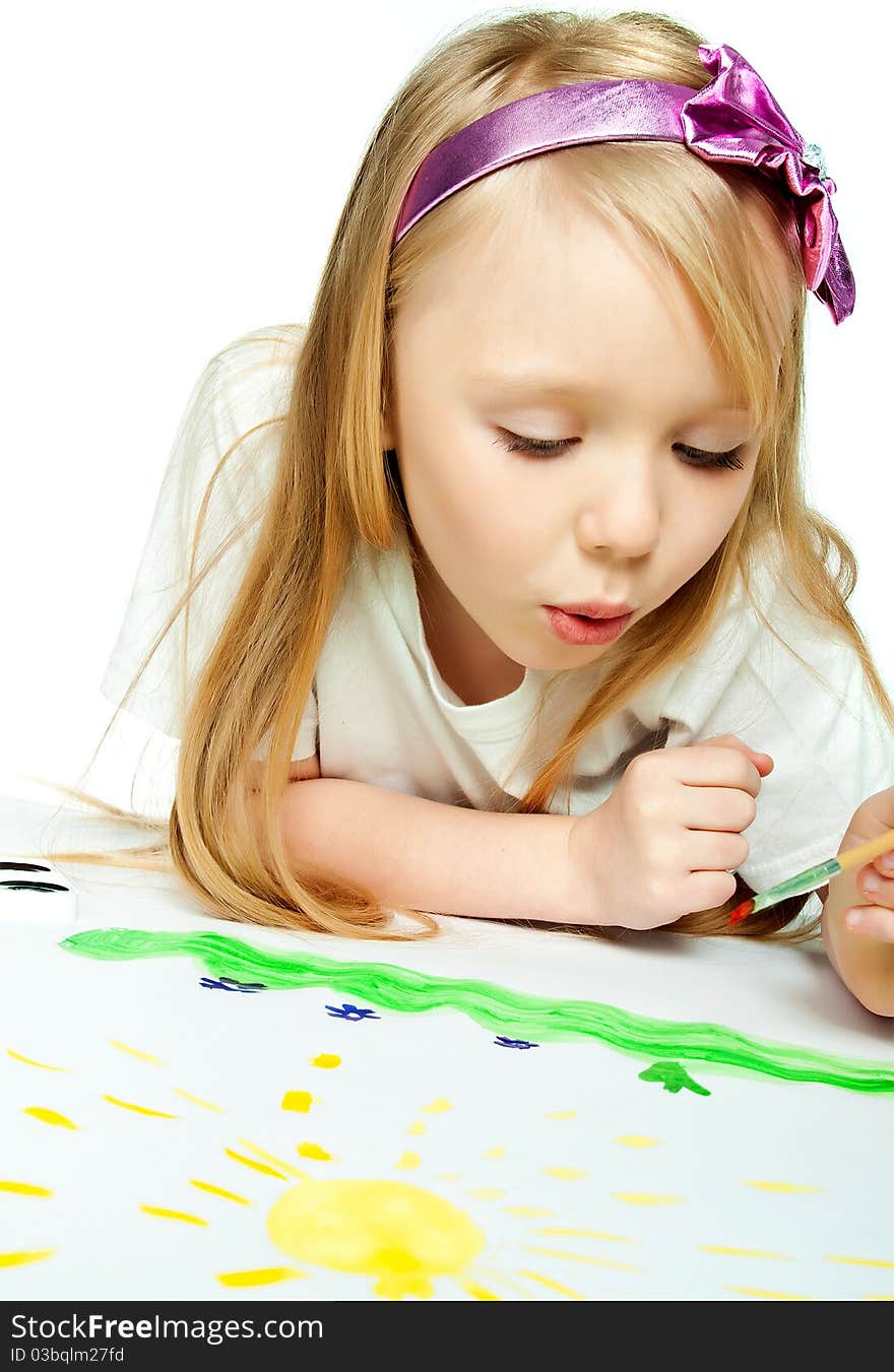 Cute little girl with a brush and paints