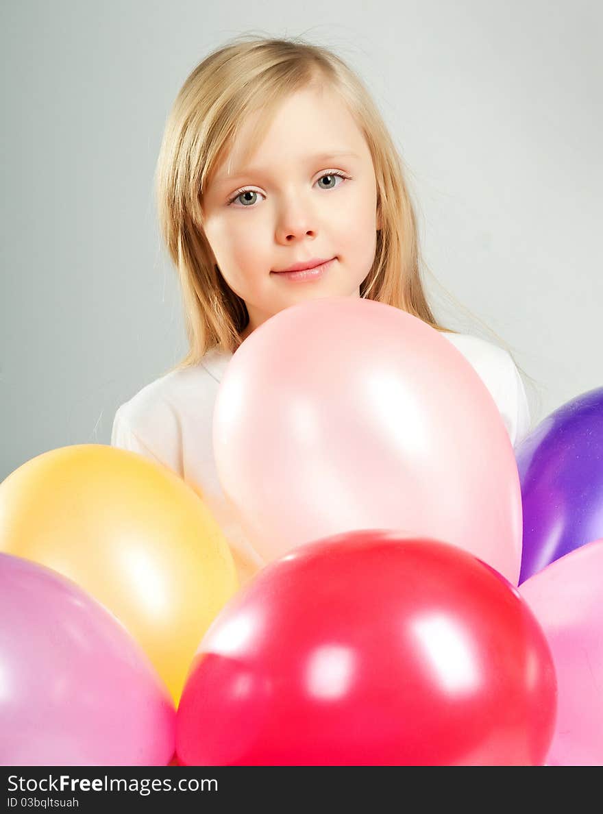 Cute little girl with balloons on white