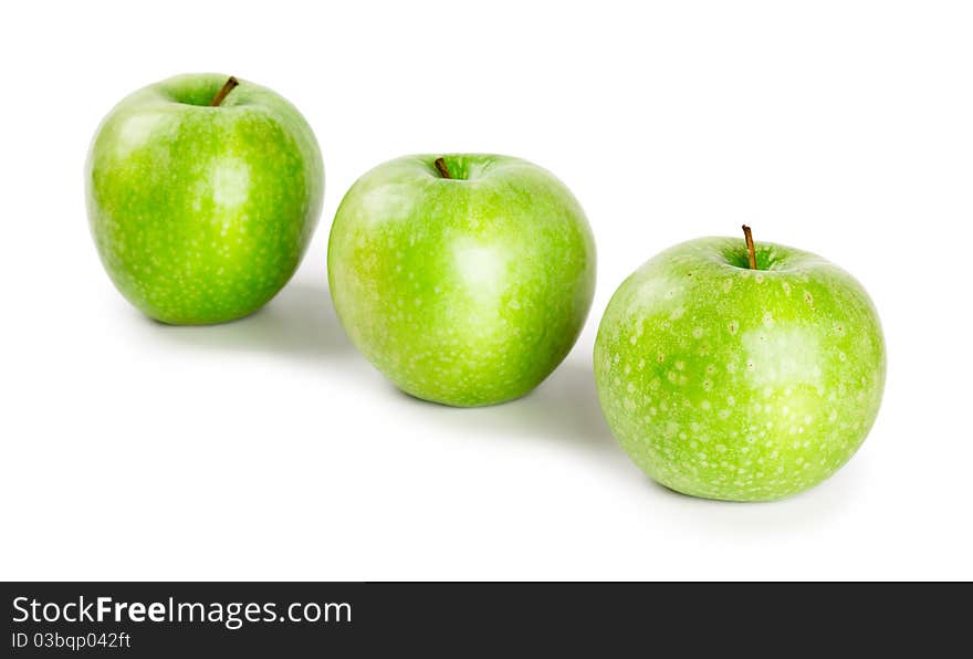 Three ripe and juicy green apples located in a line isolated on a white background. Three ripe and juicy green apples located in a line isolated on a white background