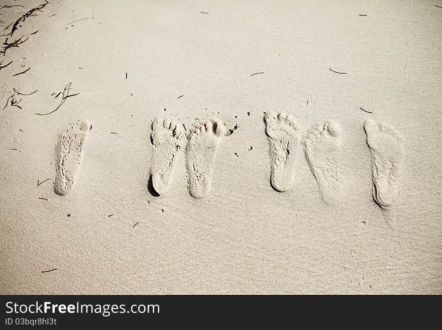 Six footsteps on the sand on the beach