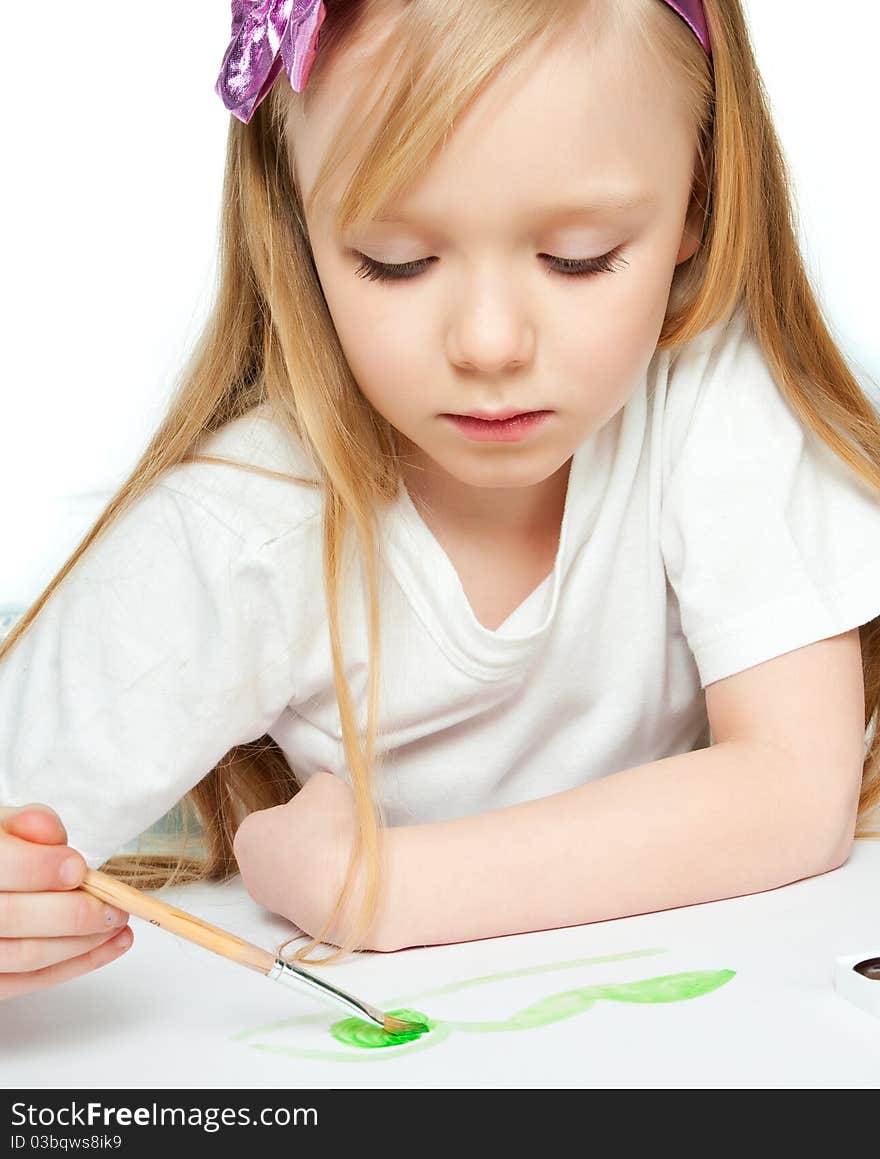 Cute little girl with a brush and paints