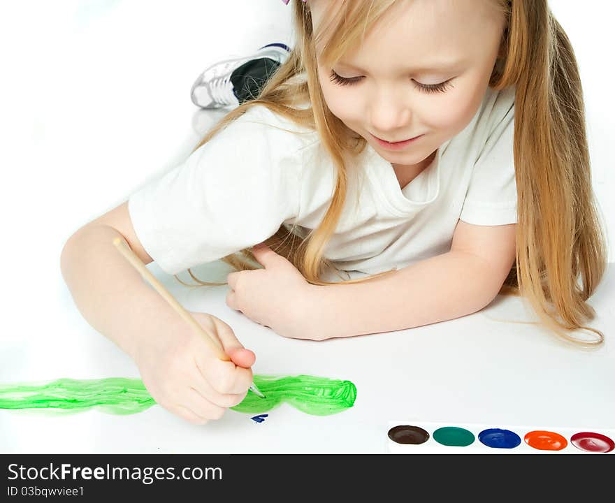 Cute little girl with a brush and paints