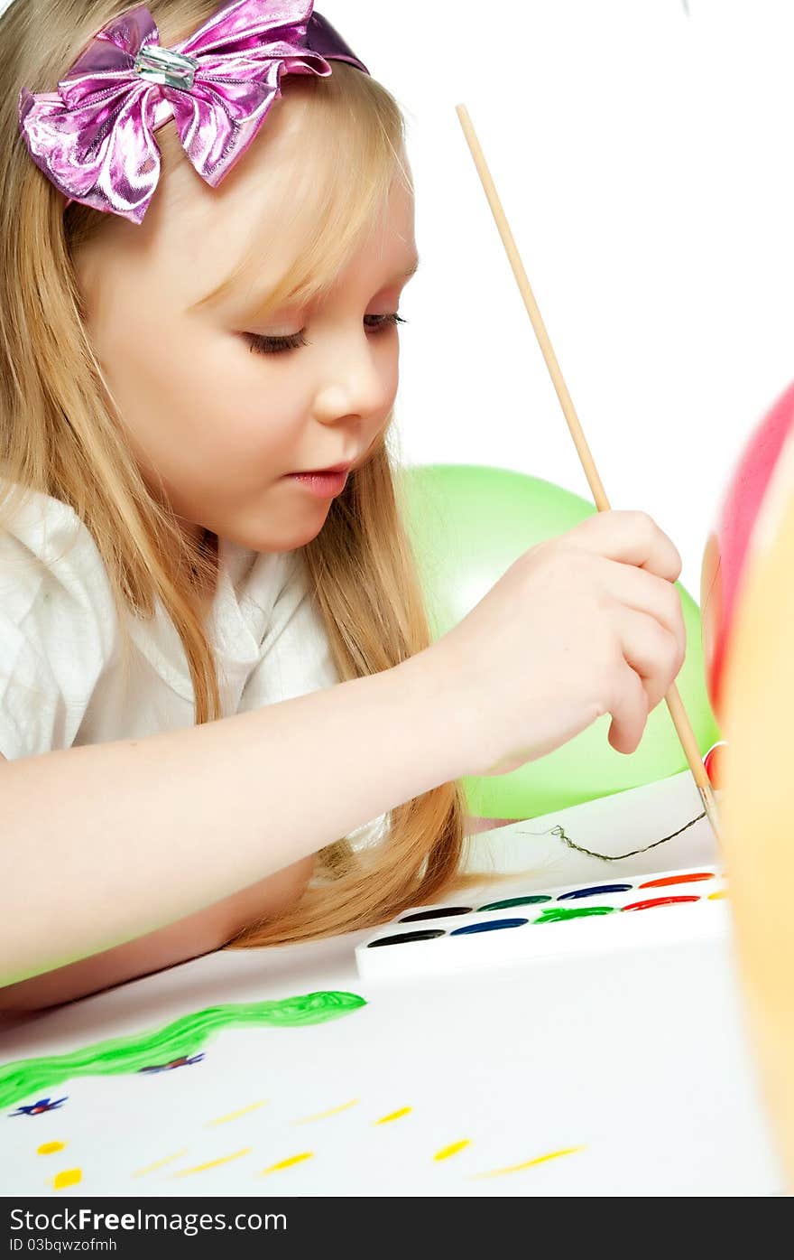 Cute little girl with a brush and paints