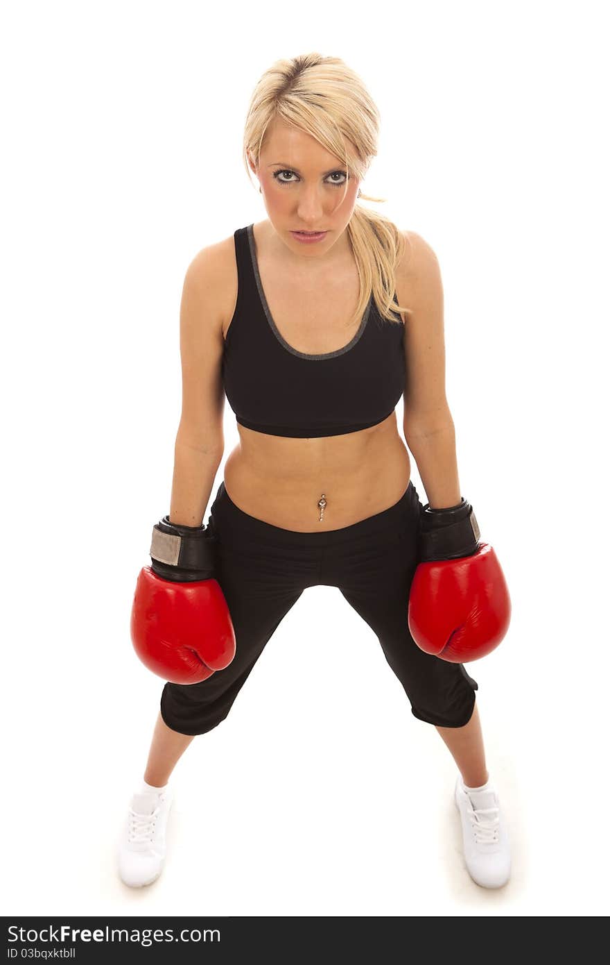 A pretty young girl wearing red boxing gloves with a determined look. A pretty young girl wearing red boxing gloves with a determined look