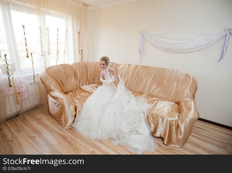 Happy bride waiting for a groom on the sofa. Happy bride waiting for a groom on the sofa