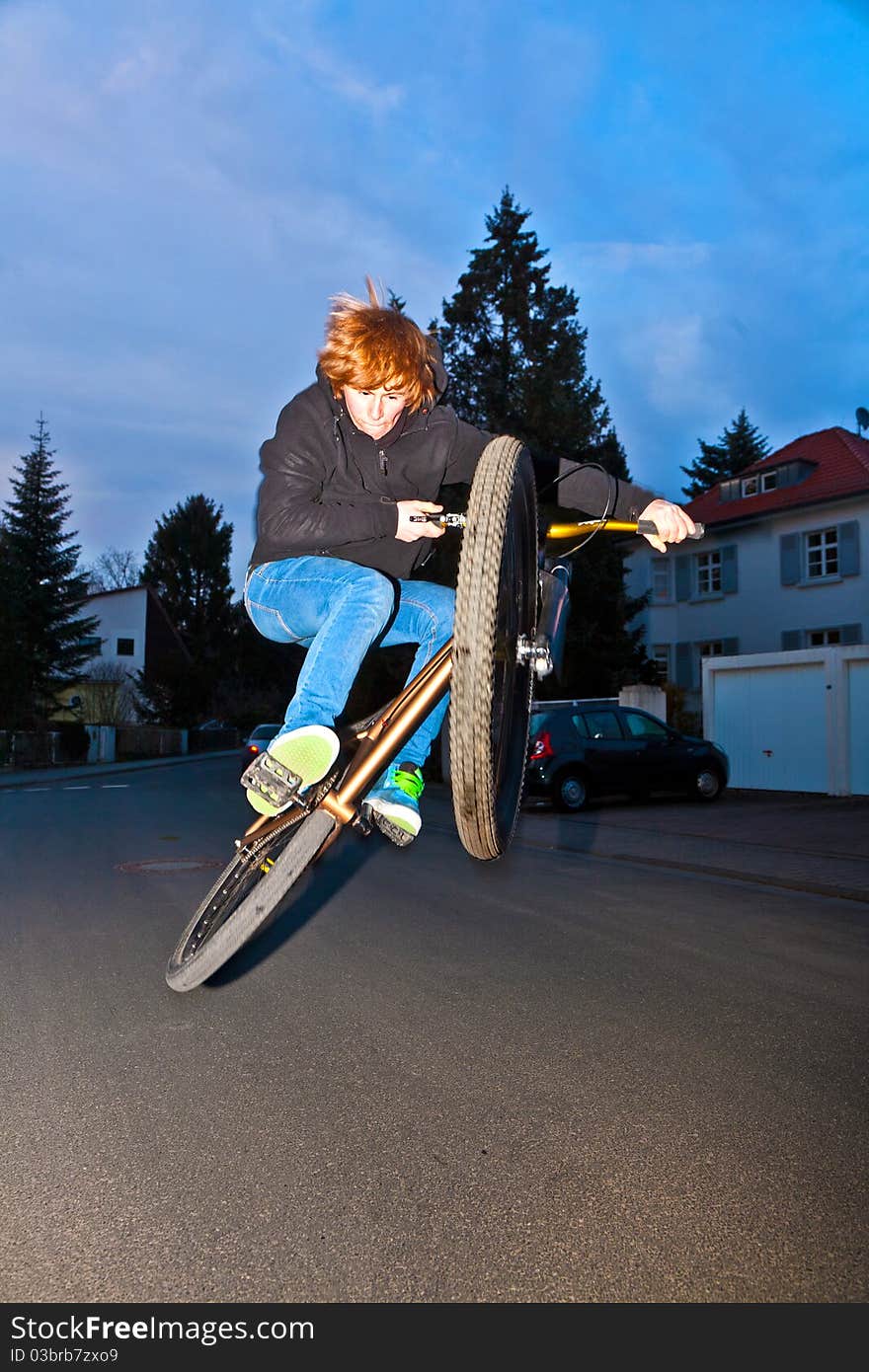 Boy with dirtbike is going airborne by night