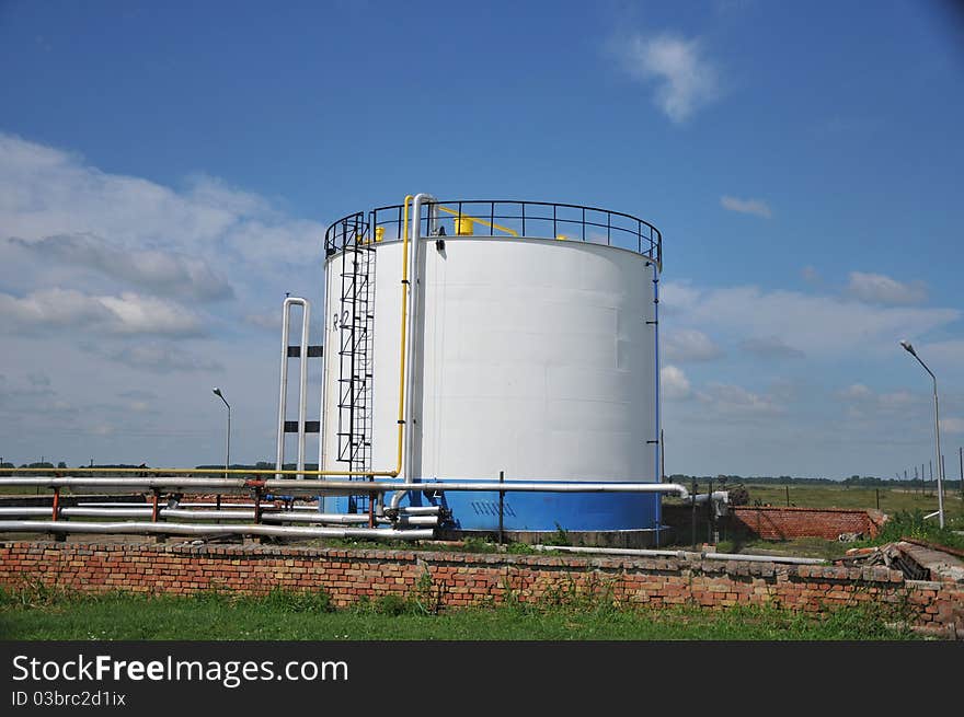 Oil tank with stairs against blue sky