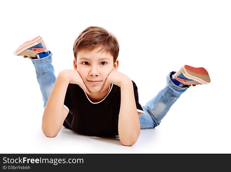 Portrait of a happy 9 year boy lying on a floor. Isolated over white background.