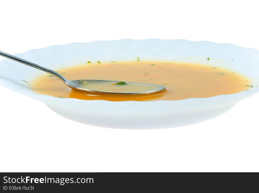 Spoon in a soup plate on white background