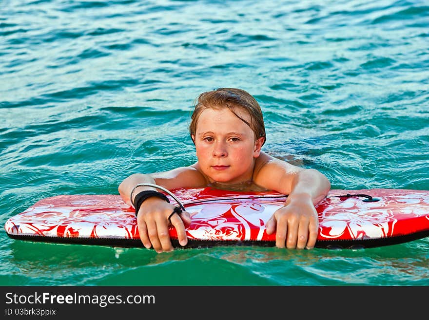 Boy ij the ocean is exhausted from surfing. Boy ij the ocean is exhausted from surfing