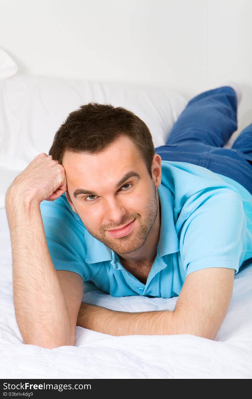 Young smiling man in white interior. Young smiling man in white interior