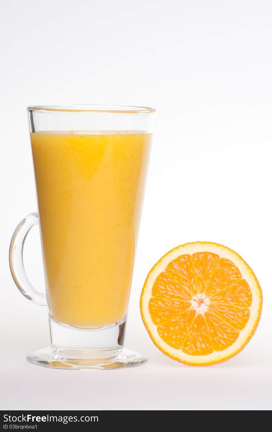 A cup of fresh made, home made, healthy, tasty orange juice in glass cup with an orange next to it. A cup of fresh made, home made, healthy, tasty orange juice in glass cup with an orange next to it