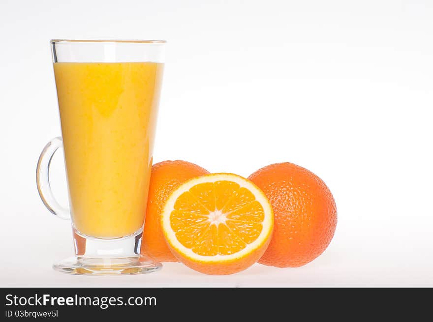 A cup of fresh made, home made, healthy, tasty orange juice in glass cup with an oranges next to it. A cup of fresh made, home made, healthy, tasty orange juice in glass cup with an oranges next to it