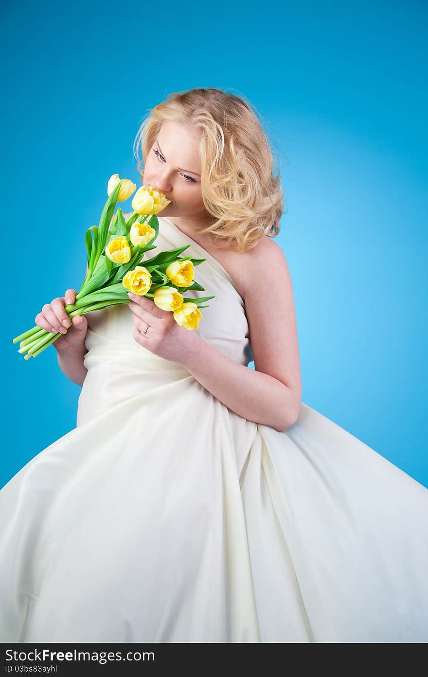 Young beautiful woman with flowing hair holding a bouquet of tulips