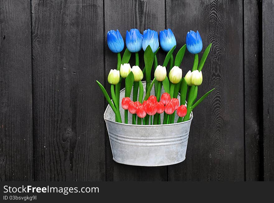 Colorful wooden flowers against black wall