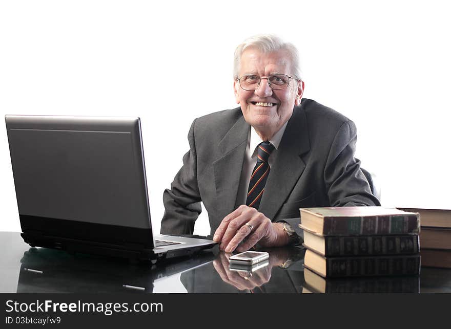 Smiling senior businessman using a laptop. Smiling senior businessman using a laptop