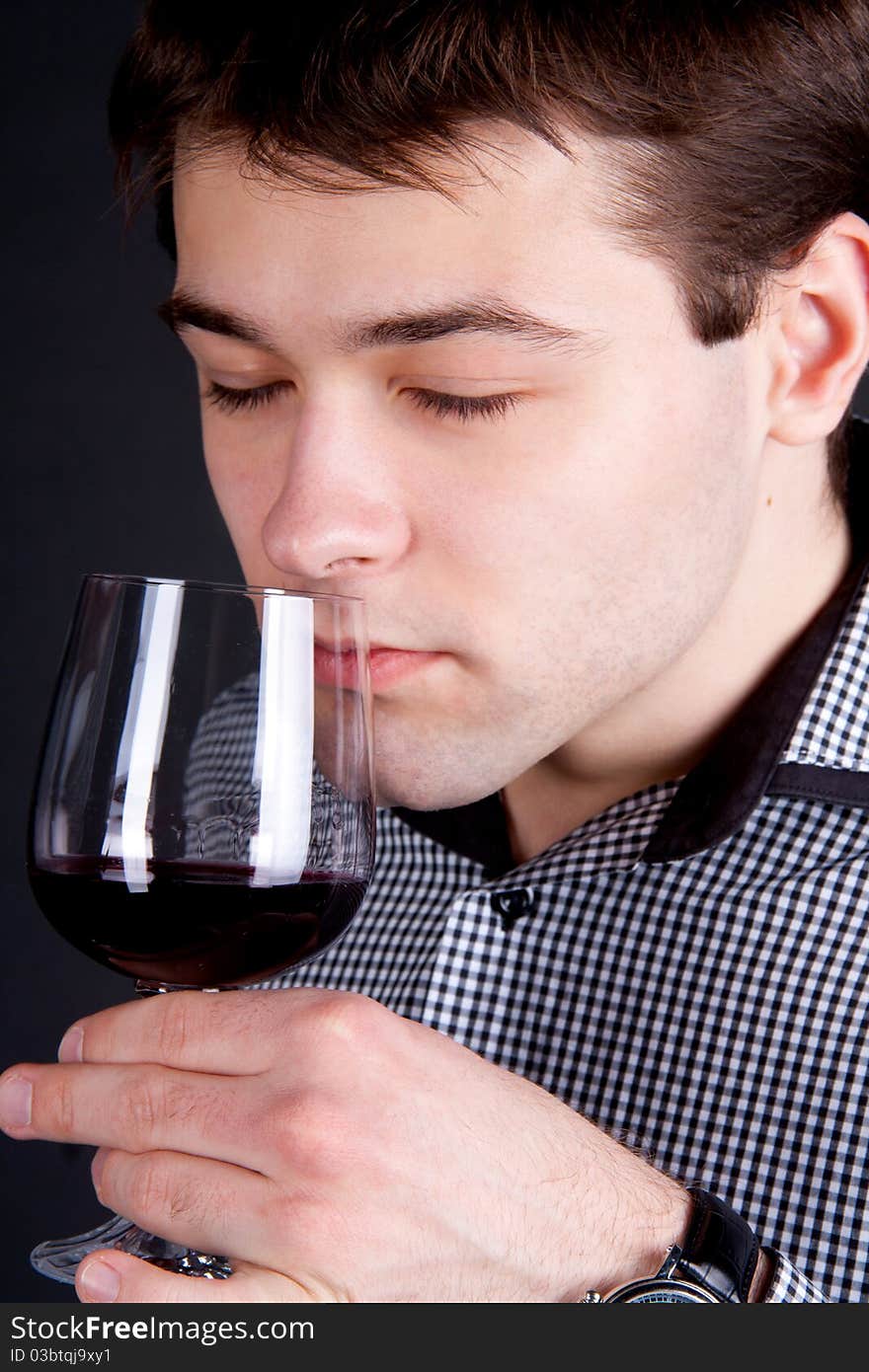 Young Man Smelling A Glass Of Red Wine