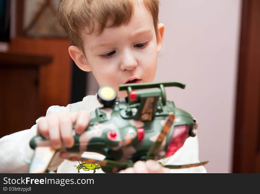 Little boy playing with toy helicopter at home on the floor. Little boy playing with toy helicopter at home on the floor