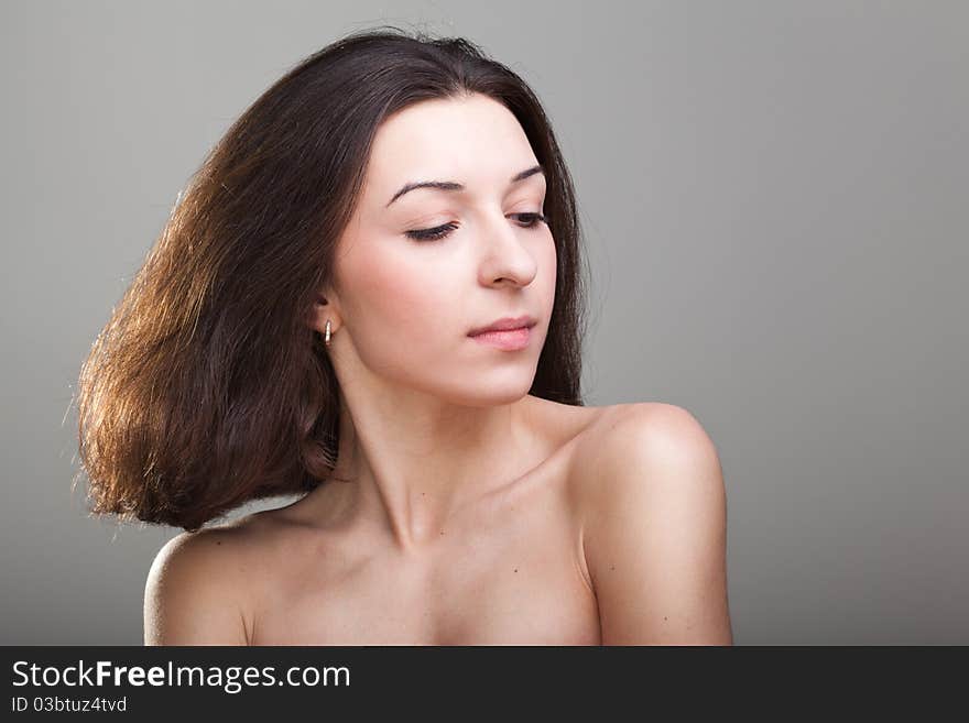 Young beautyful woman in the studio on a grey background