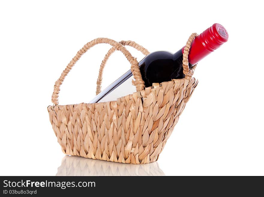 A bottle red wine on a gift wicker basket isolated over white