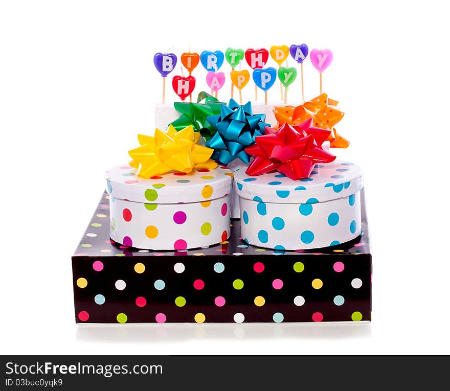 Cheerful dotted gift boxes with bows and birthday candles isolated over white