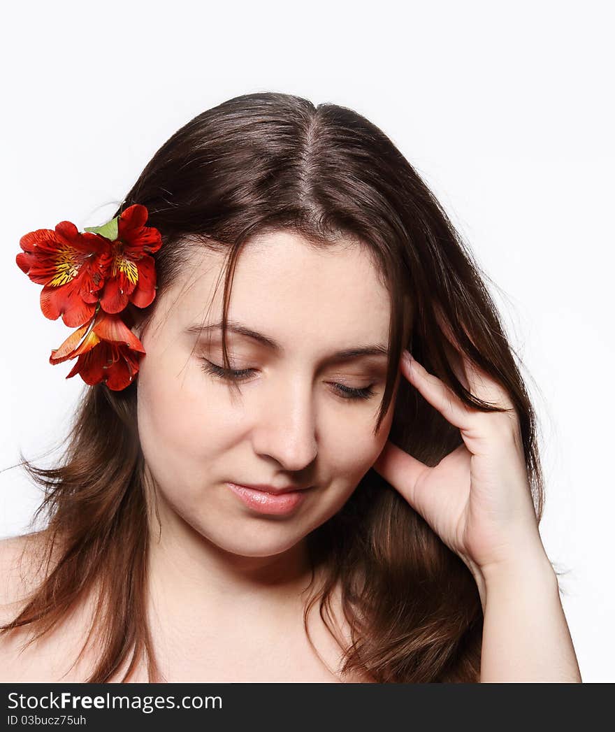 Portrait of the beauty young brunette girl with lily in her hair