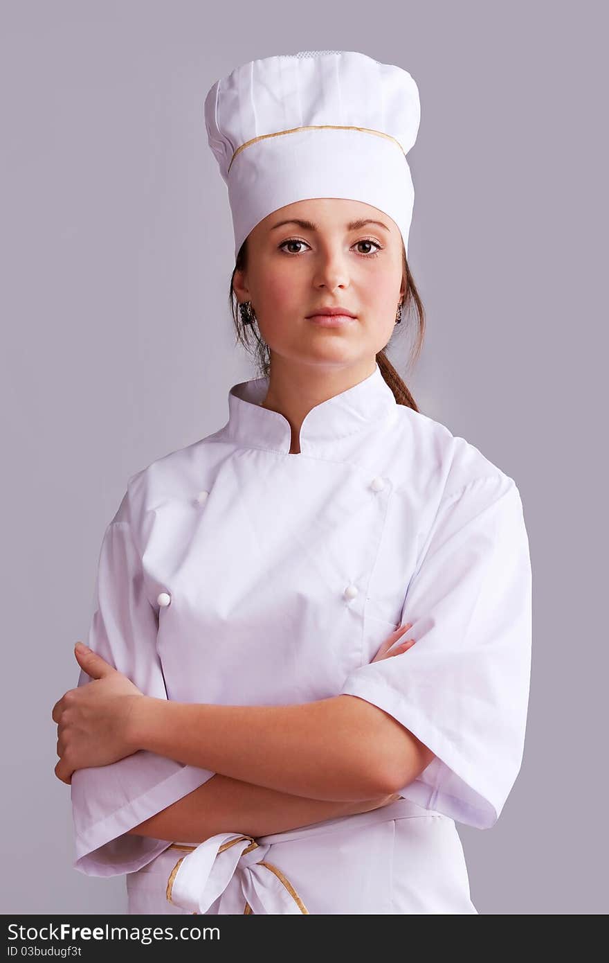 Young woman in white chef dress with hat. Young woman in white chef dress with hat