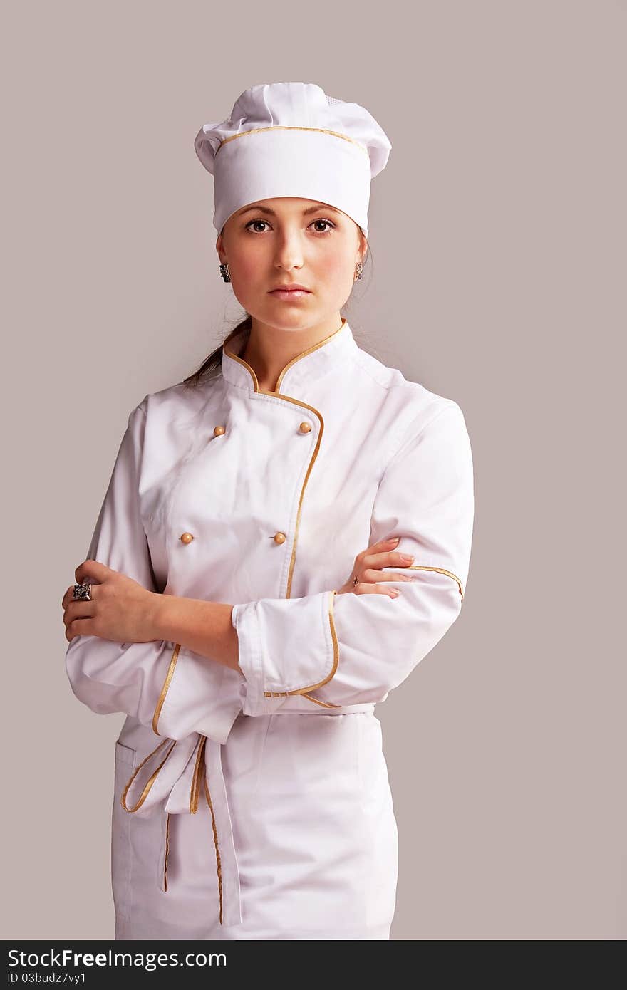 Young woman in white chef dress with hat. Young woman in white chef dress with hat