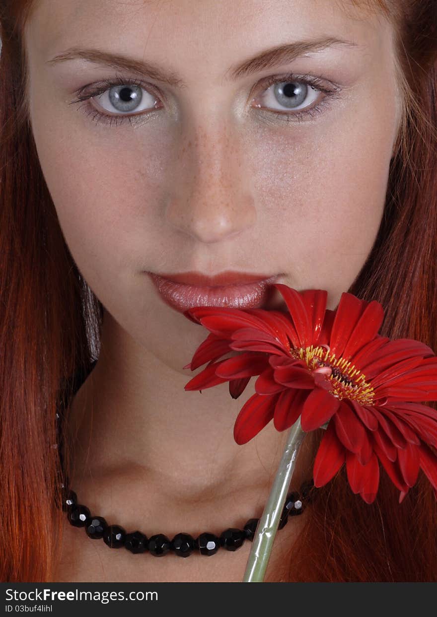 Portrait of the red-haired girl with a red flower. Portrait of the red-haired girl with a red flower