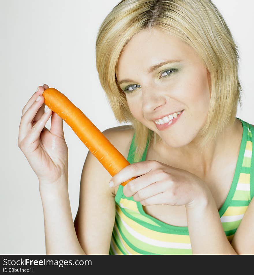 Portrait of young woman with a carrot