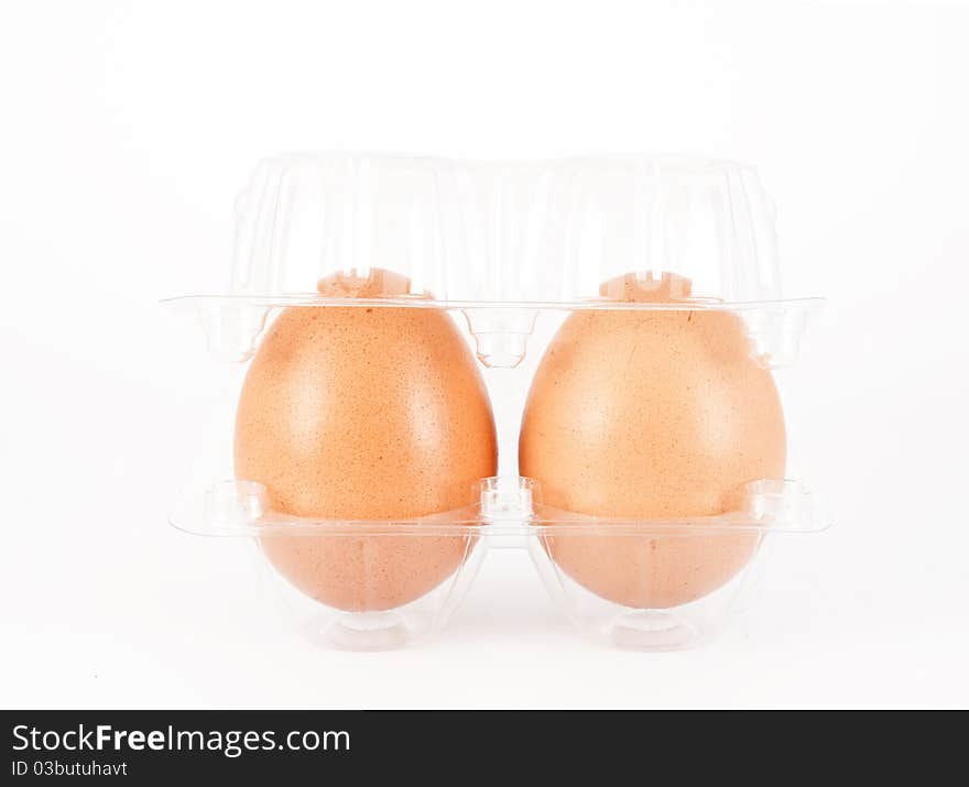 Pair of eggs on a plastic packing over white background