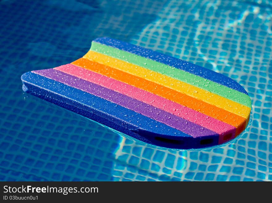 A rainbow colored water board in a pool. A rainbow colored water board in a pool