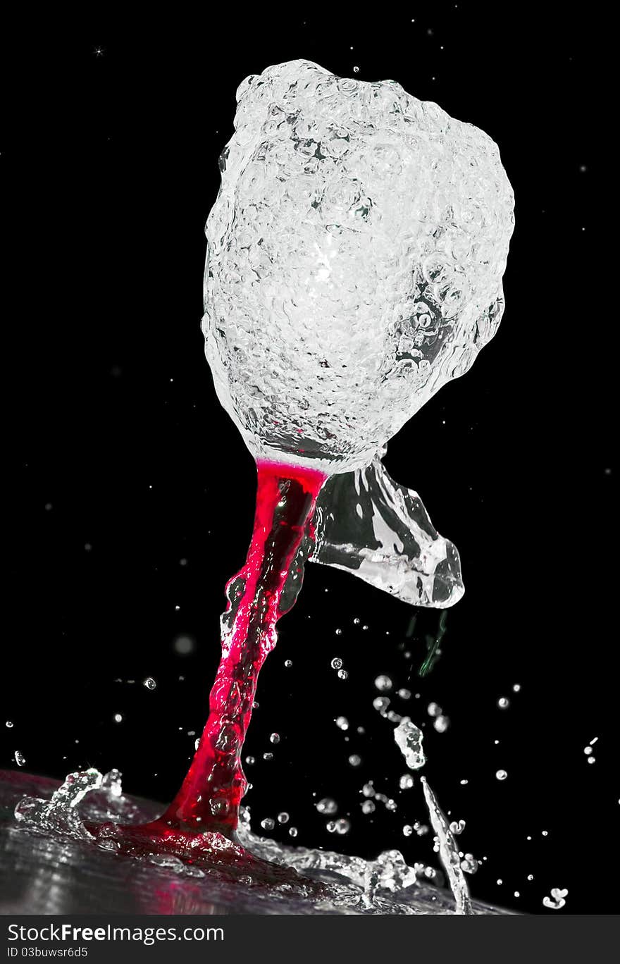 Red wine glass in a spray of water, a black background