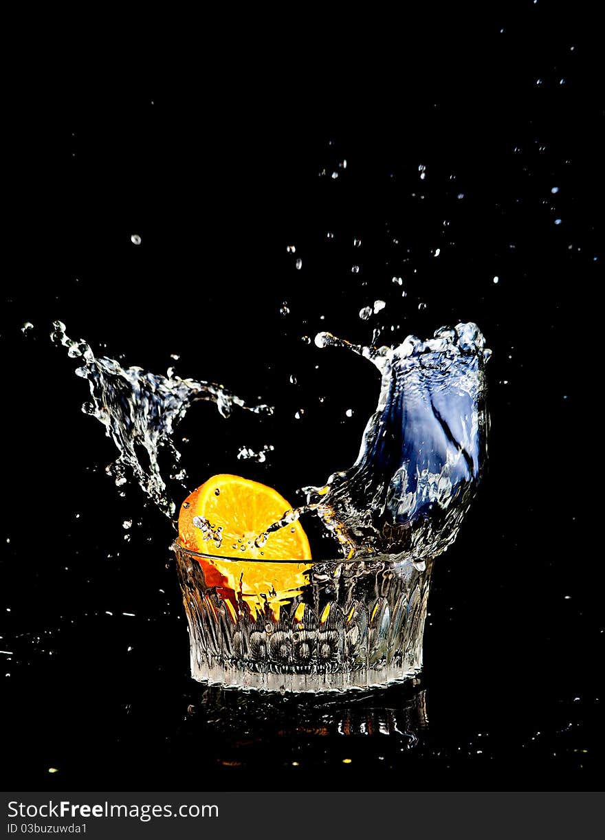 Subject shooting. The orange falls in a water glass. Subject shooting. The orange falls in a water glass.