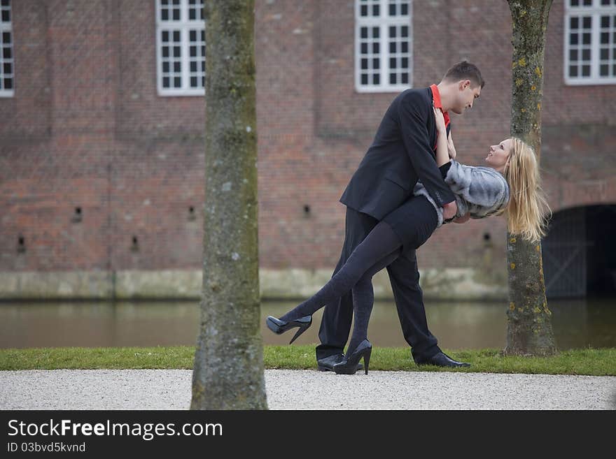 Love couple in park - man holding woman in his hands